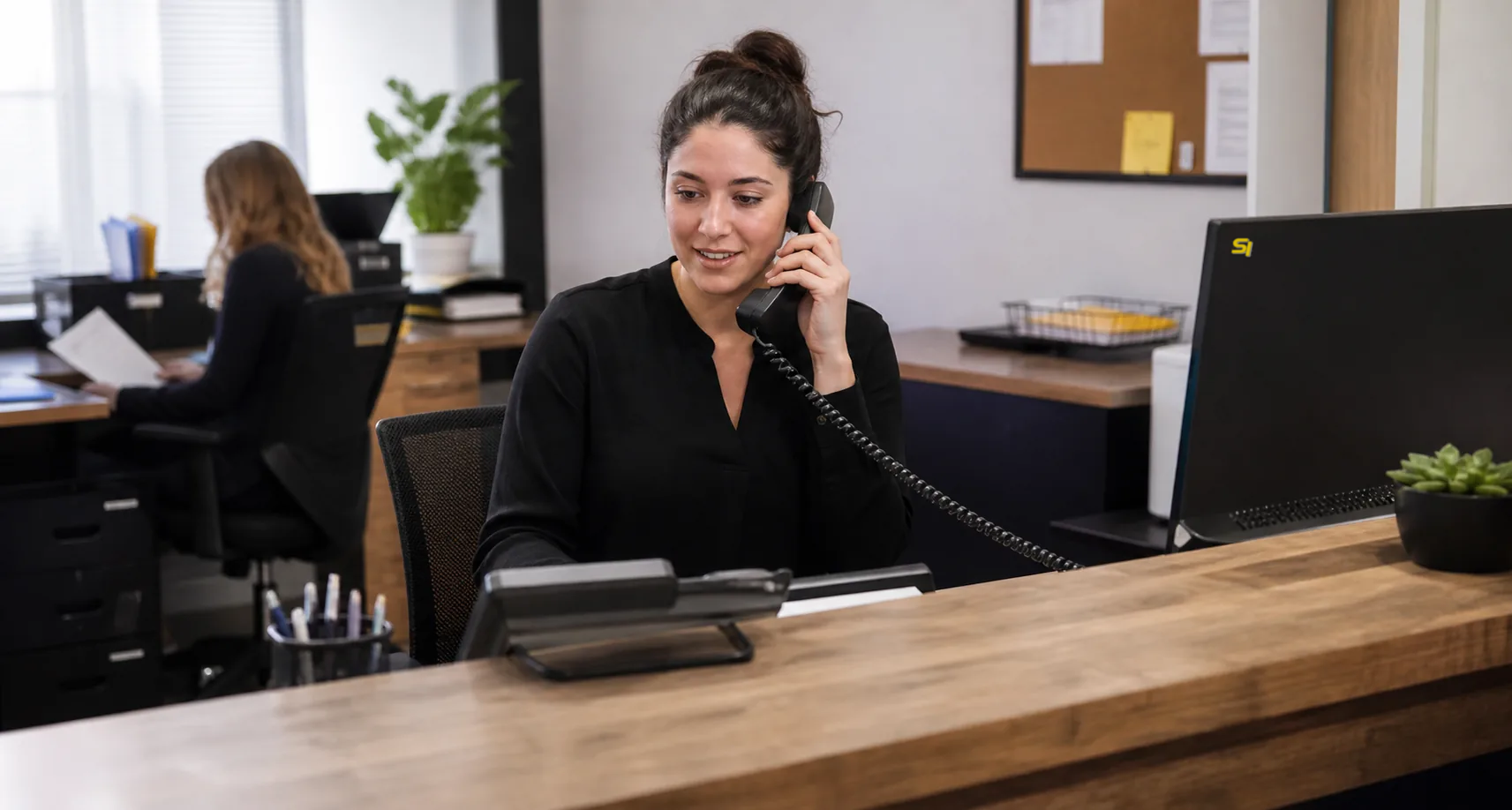 Office worker handling a call on a desktop business telephone