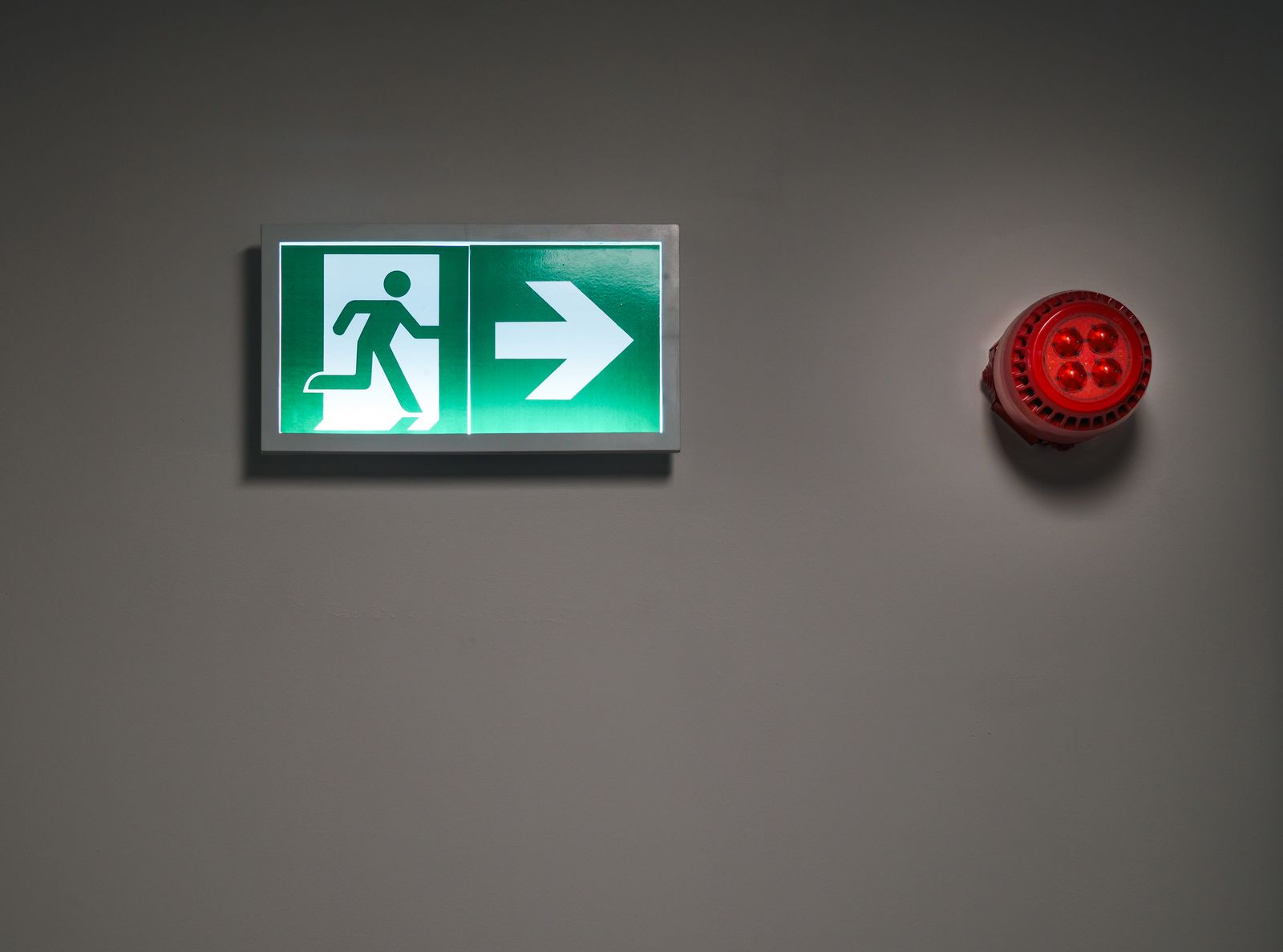 Illuminated emergency exit sign in a corridor