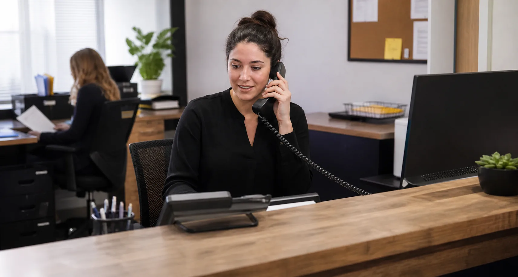 Office worker handling a call on a desktop business telephone