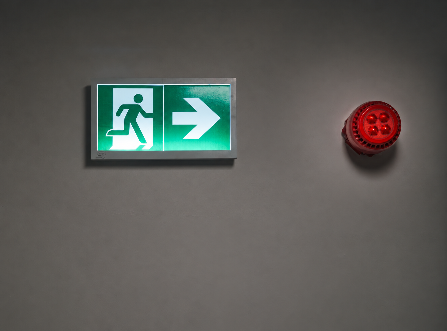 Illuminated emergency exit sign in a corridor